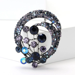 Macro shot of silver-tone brooch with dark blue and purple crystals on white blocks