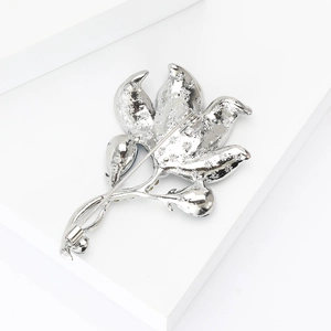 Detail view showing the secure pin fastener and back structure of the lily brooch
