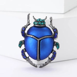 Dettaglio macro della spilla a scarabeo con smalto blu e strass brillanti su metallo