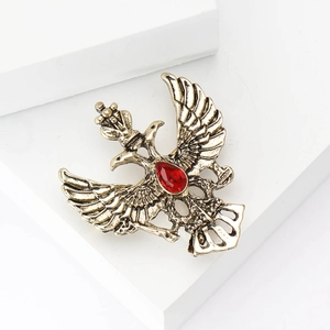 Broche de águila rusa con diamantes de imitación y cristal rojo en fondo blanco