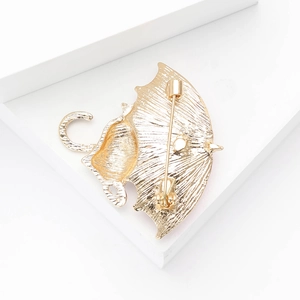 Detailed back view of gold alloy cat brooch showing secure safety pin and brushed texture