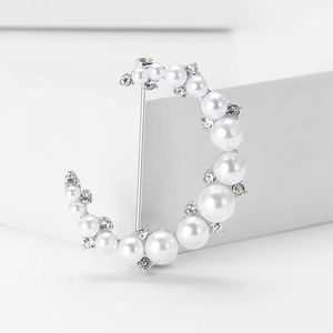 Détail de la broche croissant de lune avec perles blanches et cristaux sur base argent