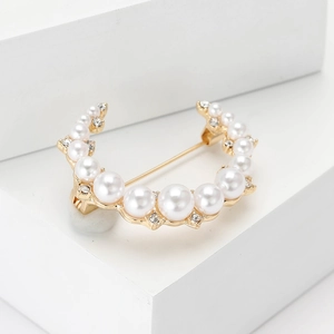 Élégante broche lune dorée avec perles blanches et petits cristaux sur socle minimaliste