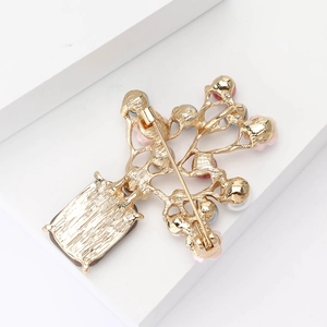 Détail d'une élégante broche vase à fleurs en alliage avec fermoir en métal et perles blanches