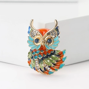 Détail de la broche hibou en alliage avec émail coloré et strass brillants sur fond blanc