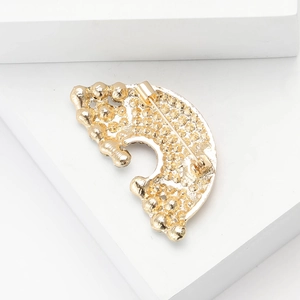 Macro shot of the polished gold-plated alloy brooch back showing a secure pin clasp mechanism