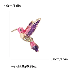 Dettaglio della spilla a forma di colibrì colorata con dimensioni e peso sul bianco