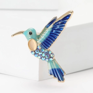 Elegante spilla a colibrì con smalto blu sfumato e strass su espositore bianco