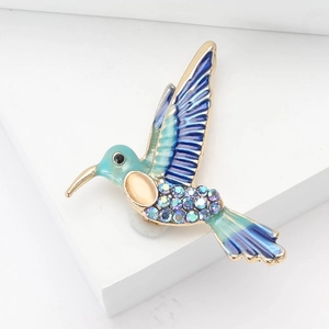 Spilla a colibrì alla moda con smalto blu e cristalli su base in metallo dorato