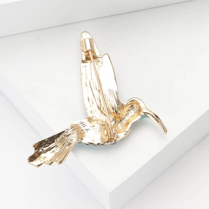 Dettaglio del retro della spilla a colibrì con chiusura sicura e placcatura dorata
