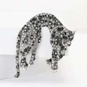 Macro detail of high-quality leopard brooch with sparkling rhinestones on white display