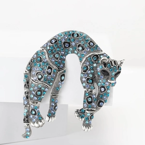 Detailed close-up of a silver leopard brooch with gradient blue and purple rhinestones