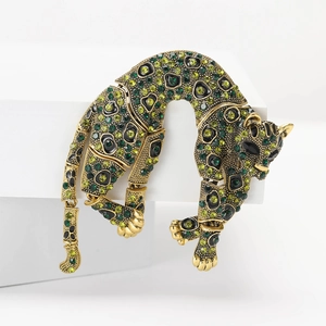Vintage gold leopard brooch featuring green rhinestones in a moving animal design