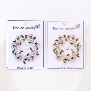 Close-up of elegant floral wreath brooches with colorful rhinestones on a display card