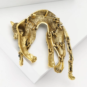 Detailed macro view of vintage leopard brooch with articulated joints and green rhinestone eyes