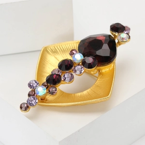Broche vintage dorée avec cristaux violets sur un support géométrique moderne élégant