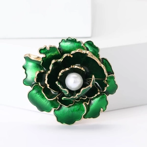 Détail macro d'une broche pivoine en émail vert de style chinois avec perle et bord doré