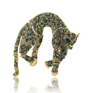 Articulated golden leopard brooch featuring sparkling rhinestones and green crystal eyes
