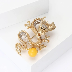 Elegant gold alloy dragon brooch featuring white rhinestones and a yellow pearl bead