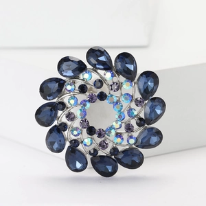 Detail shot of silver floral brooch with deep blue pear-cut rhinestones and colorful crystals