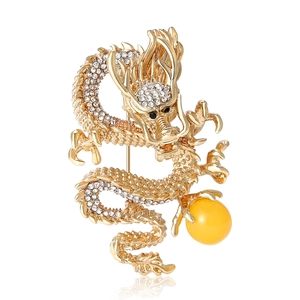 Elegant gold alloy Chinese dragon brooch with white rhinestones and a yellow bead detail