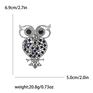 Vintage hollow owl brooch with blue rhinestones and silver metal finish, size 6.9cm by 5.0cm