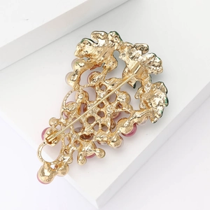Detail view showing the secure metal pin buckle and gold-plated back of the grape brooch
