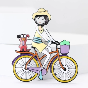 Detaillierte Makroansicht einer hochwertigen Acryl-Brosche: Mädchen auf dem Fahrrad mit Hund