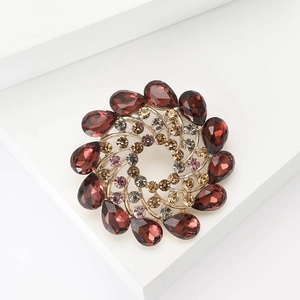 Elegant gold alloy flower brooch with red pear-cut rhinestones on white geometric stand
