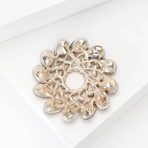 Detailed back view of a gold alloy flower brooch showing metal pin and hollow structure