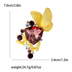 Elegant gold butterfly brooch with red gemstone and colorful rhinestones on white background