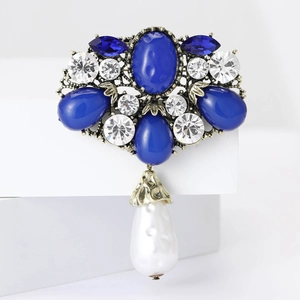 Detail of vintage Baroque brooch with blue gems, clear rhinestones and teardrop pearl