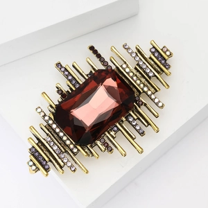 Makroaufnahme der Vintage-Brosche mit rotem rechteckigem Edelstein und Goldstrahlen