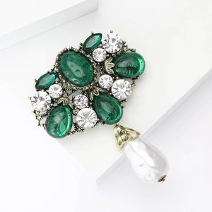 Baroque style brooch with emerald green crystals and a large white teardrop pearl pendant