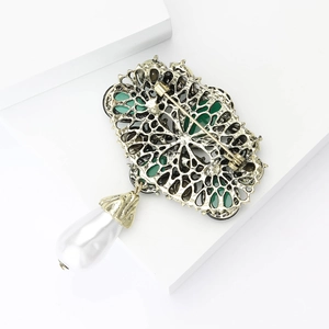Detailed back view of baroque brooch showing secure safety pin and hanging pearl drop