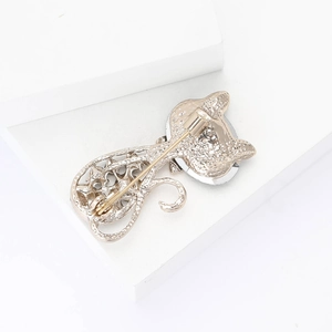 Detail view of the metal safety pin closure on back of hollowed-out cat brooch