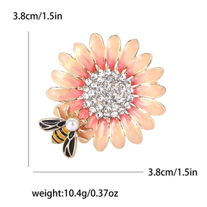 Dettaglio della spilla a girasole in smalto con cuore di strass e ape con perla