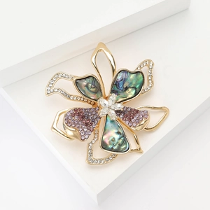 Elegant vintage alloy flower brooch with rhinestone and shell inlay on white stand