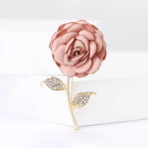 Makro-Detail einer 3D-Stoffrose-Brosche mit goldenen Blättern und Kristall-Strasssteinen