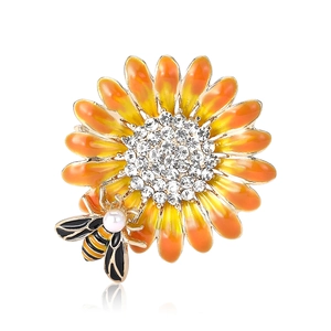 Spilla squisita con girasole smaltato, ape, strass e perla su sfondo bianco pulito