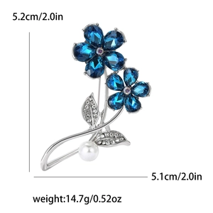 Vue détaillée de la broche fleur avec cristaux bleus et dimensions de 5,2 cm x 5,1 cm