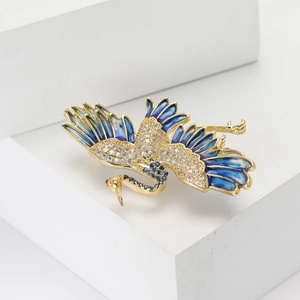 Exquisite crane brooch in gold-tone copper with blue enamel and sparkling cubic zirconia