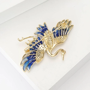Detailed back view of crane brooch showing gold plating and secure safety pin fastener