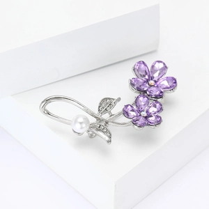 Broche fleur violette élégante avec cristaux et perle blanche sur une base en argent