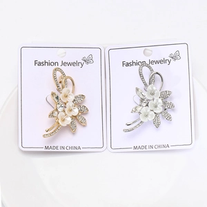 Detailansicht der Blumen-Broschen in Silber und Gold mit Kristallen und Harz-Blütenblättern