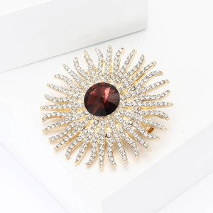 Elegant rhinestone sunflower brooch with a large deep red center stone on a gold setting