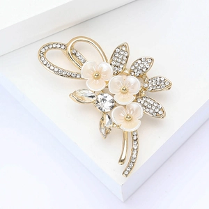 Eleganter goldener Blumenstrauß-Anstecker mit weißen Perlmuttblüten und glitzernden Strass