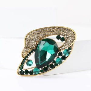 Makroaufnahme einer Vintage-Brosche mit smaragdgrünem Strass und goldenem Rahmen-Detail