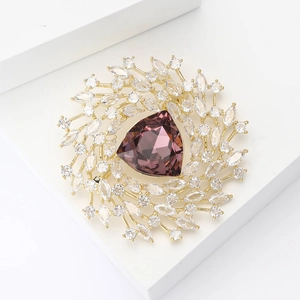 Elegant gold flower brooch with a purple triangle gemstone and white zircon accents
