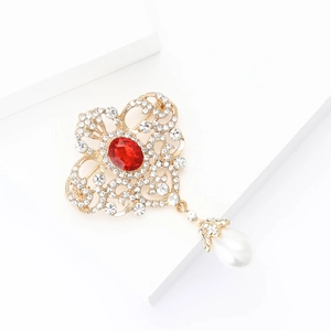 Détail de broche vintage avec pierre ovale rouge et pendentif perle en goutte